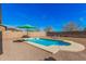 Backyard swimming pool in a gravel yard featuring lounging chairs and patio umbrellas at 19259 N Ventana Ln, Maricopa, AZ 85138