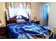 Bedroom with a four-poster bed and patterned blue blanket at 1926 E El Moro Ave, Mesa, AZ 85204