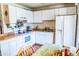 Functional kitchen featuring white appliances and cabinetry, laminate countertops, and adjacent dining area at 1926 E El Moro Ave, Mesa, AZ 85204