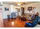 Cozy living room featuring wood floors, traditional furniture, and an adjacent open kitchen layout at 1926 E El Moro Ave, Mesa, AZ 85204