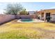 Backyard with pool, yellow grass and a patio with white furniture at 1926 E El Moro Ave, Mesa, AZ 85204