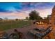 Relaxing backyard with lounge chairs and a built-in fire pit area, perfect for peaceful outdoor living at 20207 N Riverbank Rd, Maricopa, AZ 85138