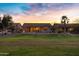 Wide backyard view featuring an outdoor patio, seating, a fire pit, and expansive green space, perfect for leisure at 20207 N Riverbank Rd, Maricopa, AZ 85138