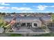 A fenced-in backyard features an outdoor fire pit, patio seating, and a view of the surrounding neighborhood at 20207 N Riverbank Rd, Maricopa, AZ 85138