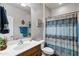 This well-lit bathroom has a vanity, a shower and tub combination with a stylish blue shower curtain at 20207 N Riverbank Rd, Maricopa, AZ 85138