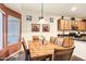 Dining room with a wooden dining table, chairs, artwork, and a view into the adjacent kitchen area at 20207 N Riverbank Rd, Maricopa, AZ 85138