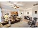 Cozy living room featuring plush seating, ceiling fan, neutral colors, and access to the dining room at 20207 N Riverbank Rd, Maricopa, AZ 85138