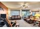 Open-concept living room with comfortable seating, ceiling fan, neutral colors, and access to outdoor spaces at 20207 N Riverbank Rd, Maricopa, AZ 85138