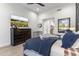 Bright bedroom with a dark wood dresser, tv, and a cozy bed with a navy and red patterned blanket at 21432 N 77Th Pl, Scottsdale, AZ 85255