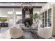 Bright living room with a fireplace, wood beam ceilings, modern chandelier, and four cozy chairs at 21432 N 77Th Pl, Scottsdale, AZ 85255