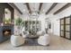 Open living room with wood beam ceilings, modern chandelier, fireplace, and hardwood flooring at 21432 N 77Th Pl, Scottsdale, AZ 85255