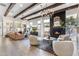 Spacious living room with wood beams, a fireplace, comfortable seating, and large windows for natural light at 21432 N 77Th Pl, Scottsdale, AZ 85255