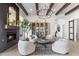 Bright living room featuring a fireplace, wood beams, modern chandelier, and stylish decor at 21432 N 77Th Pl, Scottsdale, AZ 85255