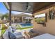 Covered patio features a seating area with a TV overlooking the pool and backyard at 21432 N 77Th Pl, Scottsdale, AZ 85255