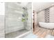 Elegant bathroom featuring walk-in glass shower, freestanding tub, and patterned accent wall for a spa-like retreat at 217 W Montecito Ave, Phoenix, AZ 85013