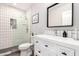 Modern bathroom with a glass-enclosed shower, white vanity, and black hardware at 217 W Montecito Ave, Phoenix, AZ 85013