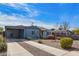 Stylish blue home with gravel landscaping, a driveway, and a covered carport at 217 W Montecito Ave, Phoenix, AZ 85013