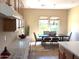 Sunlit dining room with an adjacent kitchen and a view to the backyard at 23034 N Pedregosa Dr, Sun City West, AZ 85375