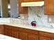 Close up of the kitchen reveals marble countertops, wood cabinets, and a marble backsplash at 23034 N Pedregosa Dr, Sun City West, AZ 85375