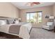 Bright bedroom featuring a king bed, golf course views, and a cozy armchair at 23034 N Pedregosa Dr, Sun City West, AZ 85375