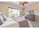 Spacious bedroom with a king bed, golf course views, and a cozy armchair near a sunny window at 23034 N Pedregosa Dr, Sun City West, AZ 85375