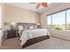 Serene bedroom with a plush bed, ceiling fan and a picturesque view of the golf course at 23034 N Pedregosa Dr, Sun City West, AZ 85375