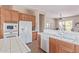 Kitchen featuring white appliances, tile countertops, and view to breakfast nook and living area at 23034 N Pedregosa N Dr, Sun City West, AZ 85375