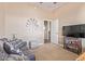 Cozy living room featuring a leather sofa, decorative windmill wall art, and a sleek entertainment center at 23034 N Pedregosa N Dr, Sun City West, AZ 85375