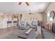 Open living room featuring tile floors, ceiling fans, gray sofa, and a view into the kitchen at 23034 N Pedregosa Dr, Sun City West, AZ 85375