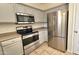 Close up of stainless steel oven, microwave, and refrigerator with matching gray cabinets in the kitchen at 2541 S Sunnyvale Ave, Gilbert, AZ 85295