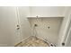 Bright laundry room featuring tile flooring, upper shelving, and convenient washer/dryer hookups at 2541 S Sunnyvale Ave, Gilbert, AZ 85295