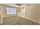 Bright and airy living room features neutral carpet and fresh paint with a ceiling fan and large window at 2541 S Sunnyvale Ave, Gilbert, AZ 85295