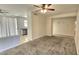 A living room with neutral walls and carpet is shown with a partial view of the kitchen at 2541 S Sunnyvale Ave, Gilbert, AZ 85295