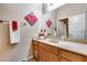 Neutral bathroom featuring a wood vanity, decorative art and a large mirror at 2571 E Balsam Ct, Chandler, AZ 85286