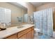 Bathroom showcasing a shower-tub combo, wood vanity, neutral walls and a large mirror at 2571 E Balsam Ct, Chandler, AZ 85286