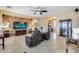 Open-concept living room features a stone accent wall, TV, leather chairs, and a glimpse of the dining area at 2571 E Balsam Ct, Chandler, AZ 85286