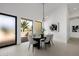 Modern dining area with black table, neutral chairs, and an open view to the outdoor patio at 2642 N Fiesta St, Scottsdale, AZ 85257