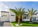 Modern home featuring a pristine lawn, palm trees, and clean architectural lines under a bright blue sky at 2642 N Fiesta St, Scottsdale, AZ 85257