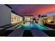 Backyard pool with lounge chairs, modern landscaping, outdoor kitchen, and views into the home's interior at 2642 N Fiesta St, Scottsdale, AZ 85257