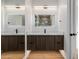 Modern bathroom with floating vanity, wood-look cabinetry, quartz countertop, and lighted mirrors at 2643 N Fiesta St, Scottsdale, AZ 85257