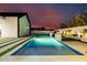 Backyard pool illuminated with tiled trim and modern landscaping set against the evening sky at 2643 N Fiesta St, Scottsdale, AZ 85257