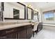 Elegant bathroom features dual sinks, dark wood cabinets, and a window offering natural light at 27000 N Alma School Pkwy # 2019, Scottsdale, AZ 85262