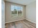 Clean, minimalist bedroom with wood-look floors, natural light from a large window, and neutral wall color at 287 N Jesse St, Chandler, AZ 85225