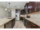 Well-appointed kitchen featuring dark cabinetry, granite countertops, stainless steel appliances, and an island with seating at 287 N Jesse St, Chandler, AZ 85225