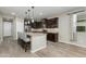 Beautiful kitchen with dark cabinets, a granite island with seating, stainless steel appliances, and wood-look flooring at 287 N Jesse St, Chandler, AZ 85225