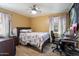 Bright bedroom with wood floors, ceiling fan, and a large window, complete with a desk at 2942 E Mulberry Dr, Phoenix, AZ 85016