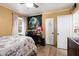 Bedroom with wood floors, ceiling fan, a large window, and bed with decorative patterned linens at 2942 E Mulberry Dr, Phoenix, AZ 85016