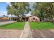 Charming single-story home featuring a well-manicured lawn and mature trees providing ample shade at 2942 E Mulberry Dr, Phoenix, AZ 85016