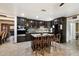 Modern kitchen with a large island, dark cabinetry, tile backsplash, and stainless steel appliances at 2942 E Mulberry Dr, Phoenix, AZ 85016