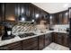 Modern kitchen with granite countertops, dark cabinets, stainless steel appliances, and tile backsplash at 2942 E Mulberry Dr, Phoenix, AZ 85016